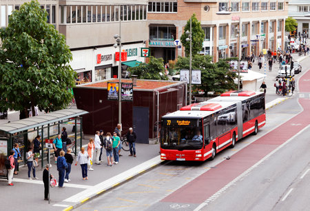 Stockholm, Sweden - August 31, 2015: Red bus in traffic for SL traffic on line 77 with the destination Karolinska Hospital arrives to stop Hornstull at the street Langholmsgatan where people are waiting.のeditorial素材