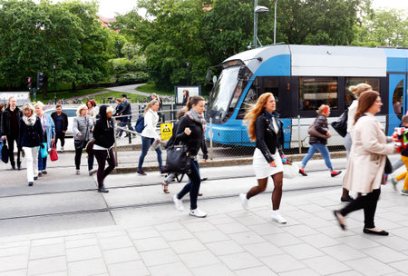 Stockholm, Sweden - June 10, 2015: Morning rush at tram stop at Liljeholmen with people walking from the tram at the public transport exchange hub Liljeholmen.のeditorial素材