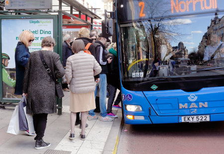 Stockholm, Sweden - April 21, 2015: A blue M.A.AN city bus on line 2 with destination Norrtull has stoped at tthe bus stop Stureplan where waiting people boarding the bus.のeditorial素材