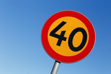 Swedish speed limit 40 road sign on blue sky.の写真素材