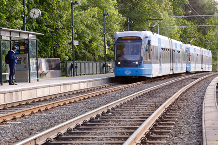 Stockholm, Sweden - June 9, 2016:A person waiting when a blue tram arriving at the tram stop Linde...