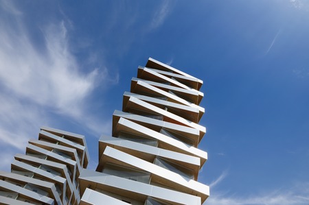 Two modern  buildings stacked like pizza boxes strive towards the sky.の写真素材
