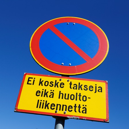 Finnish road sign parking prohibited with an additional panel, Does not apply to taxis and service vehicles, against blue sky.の写真素材