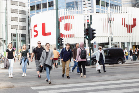 Oslo, Norway - September 16, 2016: People crossing the street on the crosswalk outside Oslo City shopping center seen in the background.のeditorial素材