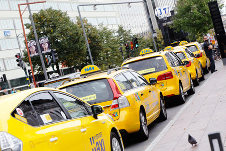 Stockholm, Sweden - September 25, 2016: A row of yellow taxi cabs parked at the taxi stand outside the Stockholm Central station.のeditorial素材