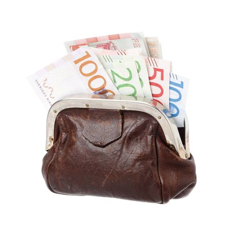 One brown purse filled with Swedish banknotes in the demoninations of 100, 200, 500 and 1000 krona, isolated on white background.の写真素材