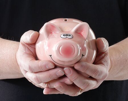 One person dressed in black shirt holding a pink piggy bank.の写真素材