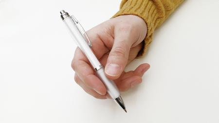 A hand holding a white ball-pen.の写真素材