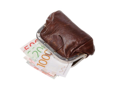 One open brown purse with Swedish banknotes inside in different denominations isolated on white background.の写真素材