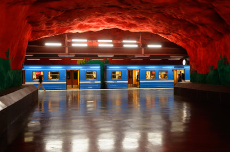 Solna, Sweden - June 6, 2016: One blue subway train in service for the Stockholm metro system has stoped and has open doors at the underground station Solna Centrum cave like metro station.のeditorial素材