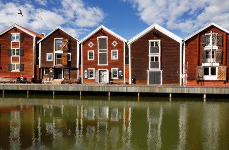 Hudiksvall, Sweden - July 5, 2017: Old red warehouses built of wood next to the water.のeditorial素材