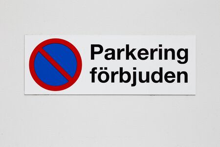 Parking prohibition sign with text in Swedish mounted on a wall.の写真素材