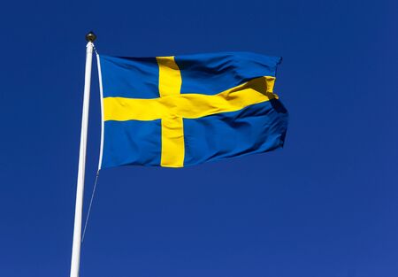 Close-up of one Swedish flag against a blue clear sky..の写真素材
