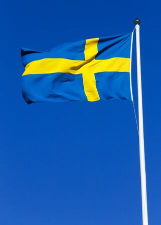 Swedish flag hoisted against a clear blue sky.の写真素材