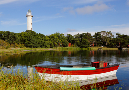 The lighthouse named Lange Erik with small fishing boat in the forground at the north end of the Swedish island Oland.の写真素材