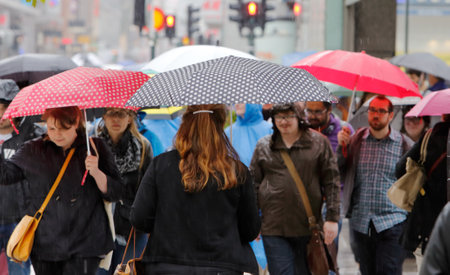 Stockholm, Sweden - July 29, 2015: People with umbrellas walking in the downtown district.のeditorial素材