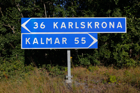 Signpost with distances and directions to the two Swedish citities Karlskrona and Kalmar.の写真素材