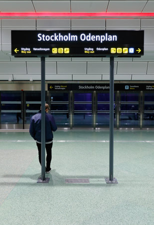 Stockholm, Sweden - September 8, 2017: A man on the platform leans with his back to the post bearing the sign with the Stockholm Odenplan station, which is an underground commuter train station in Stockholm opened in July 2017.のeditorial素材