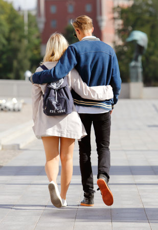 Stockholm, Sweden - July 31, 2015: A pair walks with their arms around each other near the National museum.のeditorial素材