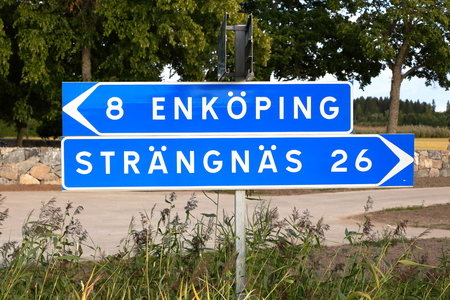 Swedish signpost with directional signs and distances to the two Swedish cities Enkoping and Vasteras..の写真素材