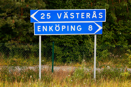 Signpost withg direction and distances to the two cities Vasteras and Enkopingの写真素材