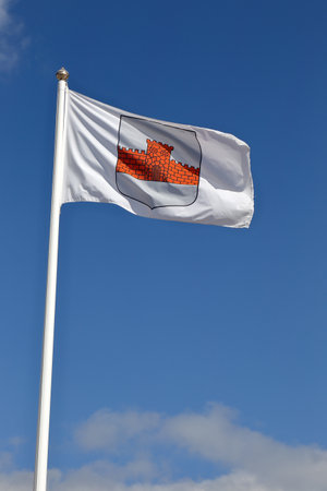 Boden, Sweden - July 13, 2015: The flag with the coat of arms for the municipality of Boden hoisted on flag pole against the blue sky.のeditorial素材