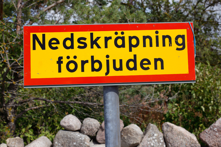 Yellow sign in Swedish with red border in the nature informs that littering is prohibited.の写真素材