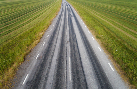 The road forward surronded by fields of grass.の写真素材