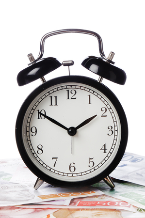 One black alaram clock standing on Swedish banknotes.の写真素材