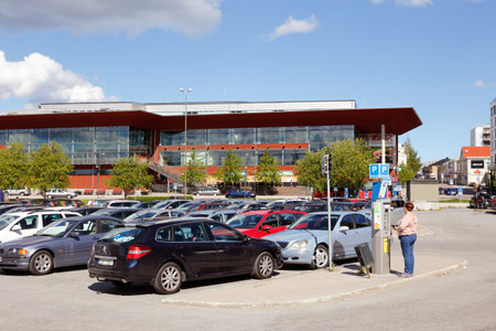 Lulea, Sweden - June 20, 2018: A woman buys a parking ticket in a vending machine at the car park infront of the public library in downtown Lulea.のeditorial素材