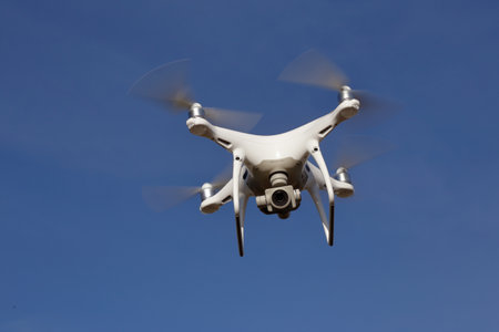 Tullgarn, Sweden - May 6, 2018: One DJI Phantom 4 quadcopter in flight against a blue sky.のeditorial素材