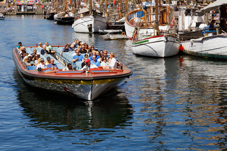 Copenhagen, Denmark - June 27, 2018: Tourists in an open top sightseeing boat in canal tour service at Nyhavn harbor.のeditorial素材