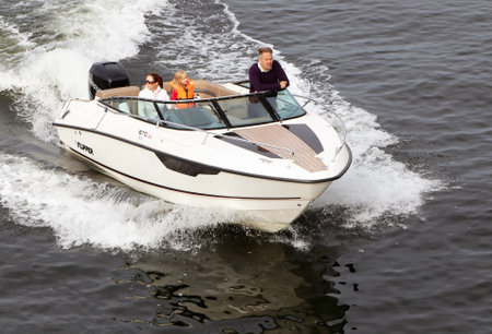 Stockholm, Sweden - September 25, 2016: Three people in an open pleasure motorboat with an outboard engine.のeditorial素材