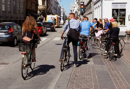 Copenhagen, Denmark - June 27, 2018: People on bicycles at the intersection with the streets Kongens nytorv and Bredgate in the downtown district waiting for green light.のeditorial素材