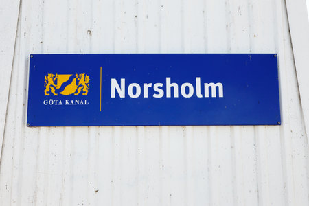 Norsholm, Sweden - July 5, 2018: Blue sign on white wooden wall at the entrance to the Norsholm locking aera in the Gota canal.のeditorial素材