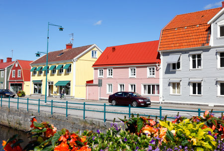 Ronneby, Sweden - August 23, 2017: Buildings and a car at Strandgatan street in downtown Ronneby during day time with flower deortions i the forground.のeditorial素材