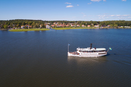 Mariefred, Sweden - July 4, 2018: Aerial view of the white passenger steamboat on lake Malaren near its destination Mariefred.のeditorial素材