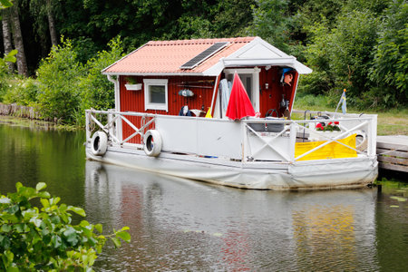 Hjalmare docka, Sweden - July 9, 2018: Small red houseboat moored in the Hjalmare canal.のeditorial素材