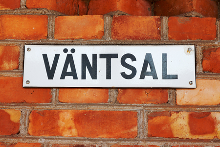 Sign with the Swedish word for waitning hall on a red brick wall.の写真素材