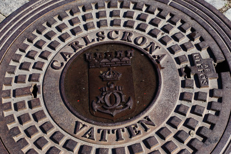 Karlskrona, Sweden - August 23, 2018: Close-up of manhole lid covers the water supply infrastructure in the city center.のeditorial素材