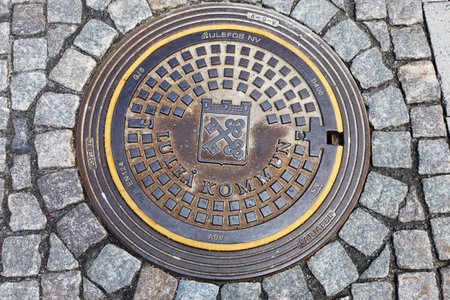 Lulea, Sweden - June 20, 2018: High angel view of a manhole lid covering a entrance to water pipe system in the street.のeditorial素材