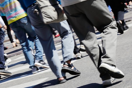 People in motion blur using a crosswalk.