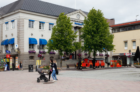 Harnosand, Sweden - July 5, 2017: A woman push a stroller at the town square.のeditorial素材