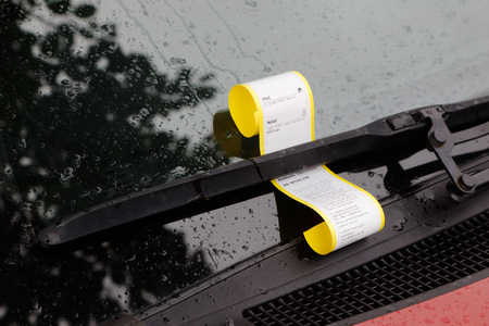 Norwegian parking ticket attached to the windscreen wiper on a car displays information about location and cause.の写真素材