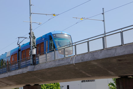 Solna, Sweden - May 23, 2016: Blue tram in service on the Tvarbanan line on the overpass at at the...