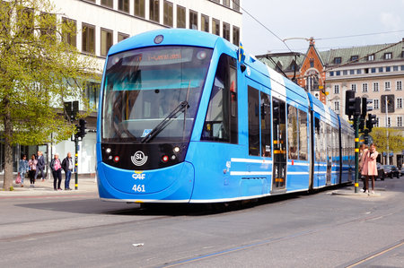 Stockholm, Sweden - April 30, 2019: One blue modern articulated tram operates line 7 at the Hamngatan street.のeditorial素材