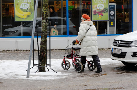 Strangnas, Sweden - Fabruary 21, 2016: Elder woman with a walker.のeditorial素材