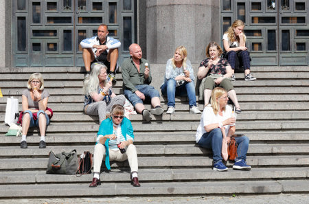 Stockholm, Sweden - June 10, 2019: People sitting in the stair case outside the Stckholm concert hall located at the Hotrget square.のeditorial素材
