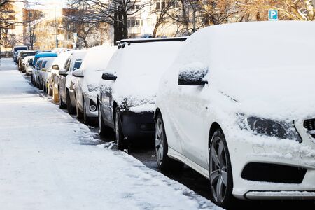 Snow covered cars parked in a residential district.の写真素材