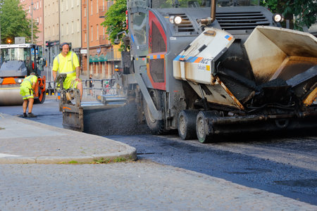 Karlstad, Sweden - June 19, 2019: The construction comapany NCC laying asphalt in the city center.のeditorial素材